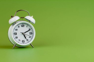 Yeşil arkaplanda alarm saati, zaman kavramı, saat fotoğrafı