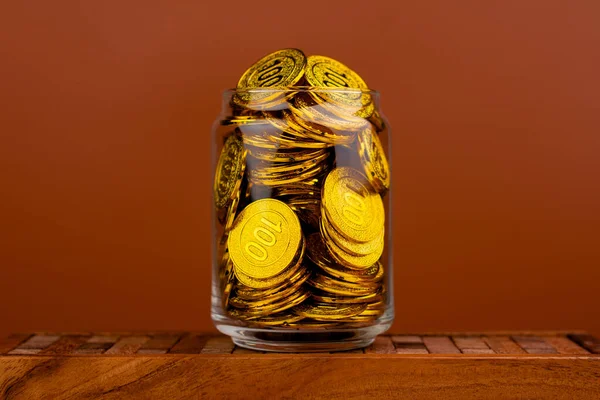 Gold Coins Save gold coins in glass jars. Concept of having money, having time and having a house