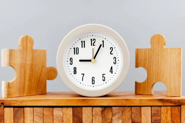 与时间值概念相对立的拼图块旁边的时钟 — 图库照片