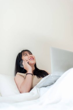 Sabahları yatakta bilgisayarla çalışmak internetten konuşma internet üzerinden iletişim kurmak tatilde çalışma kavramı.