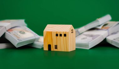 Manken ahşap ev, dolarlı oyuncak ev, ilk ev, emlak, ev kredisi, kiralık ev, ev, finansal gelir, maaş, finansal yatırım sistemi tasarruf kavramı.
