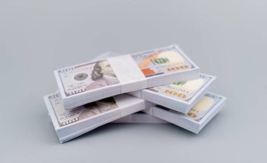 Dolarlar gri arka plana istiflenmiş. Tasarruf. Yatırım. Finansal planlama. Gelir. Maaşlar. Bölünmeler. Para ve zaman yatırım stratejisi.