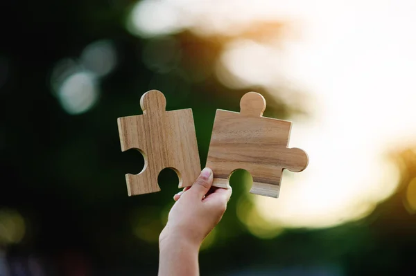 stock image Jigsaw in hand, a puzzle piece that is critical to success. Creativity, ideas, initiative, unity, teamwork