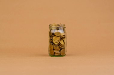 Cam kavanozda para biriktirmek, gelecek için para biriktirmek, yatırım tasarrufu, maaş, gelir, gider, finans kredisi, ev kredisi, kredi, tasarruf ve mali büyüme kavramı.