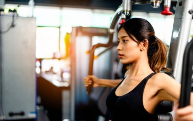 Kollarınızı bu kol egzersiz makinesiyle çalıştırın. sağlıklı kadınlar spor salonunda egzersiz yaparlar.