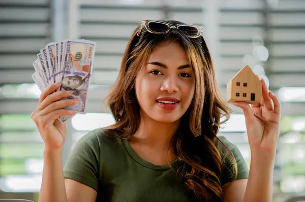 Project homes, cash loans and residential homes Young woman with a model wooden house