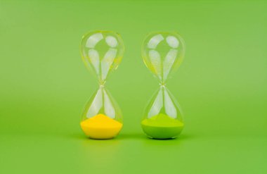 Açık yeşil zemin üzerinde yeşil ve sarı kum saati, zaman kuralları ve geri sayım zaman süreci.