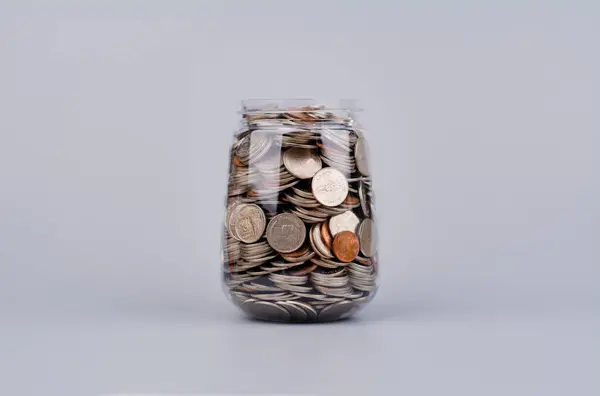 Money and time savings in a glass bottle, financial planning and investing in the stock market.