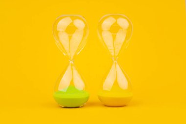 Sarı arkaplan üzerindeki kum saati, zaman ve geri sayım sınırı, son teslim tarihleri ve atamaları karşılamak için acil iş.