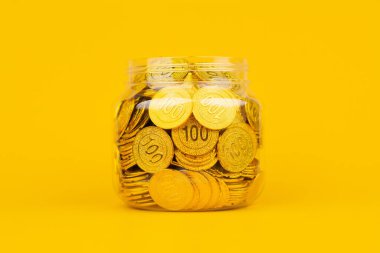 Sarı arka planda altın sikkeler, altın borsasına ve finansal büyümeye yatırım