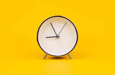 Çalar saat. Stüdyoda sabit fotoğraf sarı arka plan, zaman kavramı.