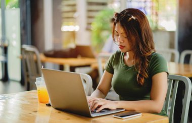 Dizüstü bilgisayarla çalışan kadın, iş yerinde serbest çalışan yaratıcı etkinlik planlayıcısı ve bağımsız finans yatırımcısıyla çalışan kadın