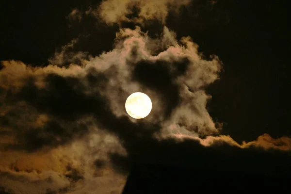 A view of the full moon and clouds. Background image of the moon.