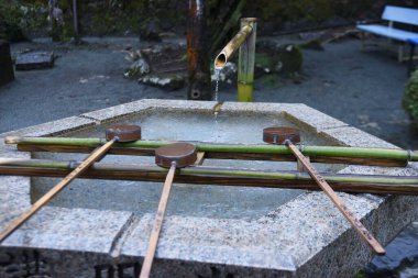 The purification fountain 'Chozuya' in the Japanese shrine. It's place where you wash your hands and rinseyour mouth at a shrine. This is a ritual cleansing.