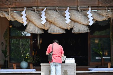 'Shimenawa' ( Shinto straw festoon ) in the japanese shrine. Shimenawa consists of a rice-straw rope and white paper cut in stripes. It is considered a barrier against evil spirits.