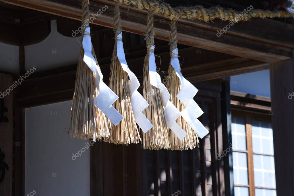'Shimenawa' ( Shinto straw festoon ) in the japanese shrine. Shimenawa consists of a ricestraw