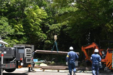 Vinç kamyonu tarafından demir direklerin ve beton direklerin çıkarılması. İnşaat alanının manzarası.