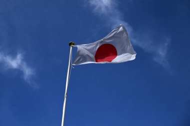 Mavi gökyüzünde dalgalanan Japon bayrağı. Japonya 'da ona' Hinomaru 'denir..