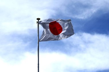 Mavi gökyüzünde dalgalanan Japon bayrağı. Japonya 'da ona' Hinomaru 'denir..