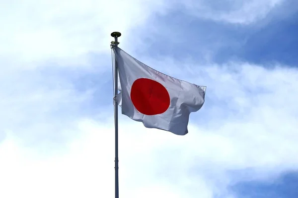 The Japanese flag fluttering against the blue sky. In Japan it is called \'Hinomaru\'.