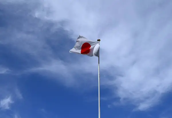 The Japanese flag fluttering against the blue sky. In Japan it is called \'Hinomaru\'.