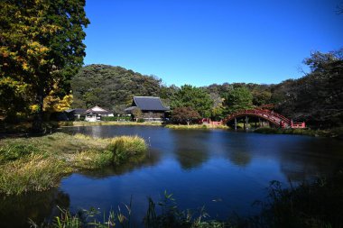  Japonya 'ya turistik gezi. 'Kanazawa-Hakkei Shomyoji Tapınağı'. Kanazawa Koğuşu, Yokohama Şehri. Tapınağın merkez göletine yansıyan kule kapısı ve ginkgo ağaçları manzarası.