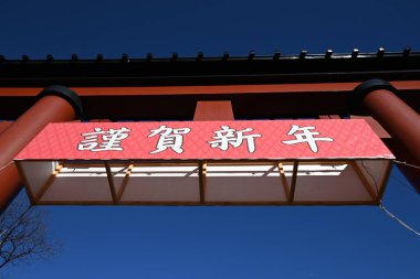 Japon yeni yıl türbesinin Torii kapısı. Kırmızı tori kapısında Japonca 'da' Mutlu Yıllar 'yazan bir plaket var..