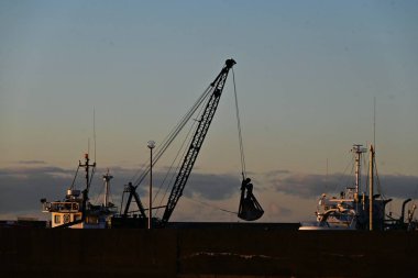 A scene of dredging work at the port. The purpose of dredging work is to scoop up sediment from the seabed with a dredger ship to ensure safe navigation of ships. clipart