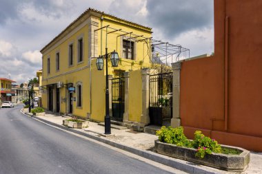 Gökyüzü bulutlu güneşli bir günde Archanes kasabasında (Heraklion Bölgesi) renkli eski geleneksel evler
