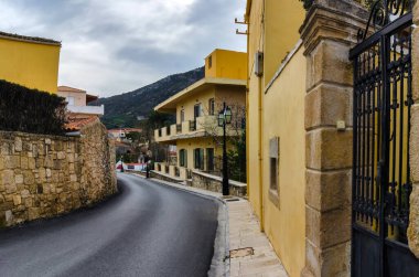 Eski renkli geleneksel evlerle Archanes kasabasının sokak manzarası. Juktas Dağı (Tanrı Zeus 'un yüzüne benzediği söylenir) arka plandadır.