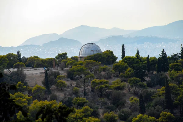 Athens, Greece. The old telescope of the National Observatory of Athens in Pnyx area on top of the Nymphs\' Hill in Thiseio. View from the Areopagus Hill in Plaka under the Acropolis of Athens city