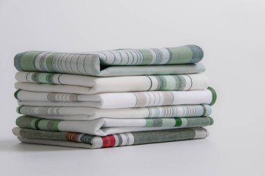 Beyaz arka planda yeşil çizgili ve ekose desenli temiz, katlanmış erkek mendilleri yığını.