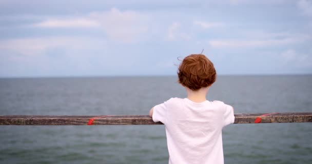 Glimlachende Roodharige Jongen Geniet Zomer Avond Houten Pier Door Oceaan — Stockvideo