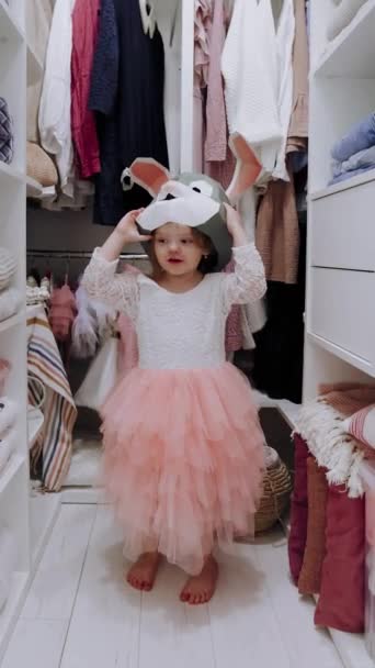 可爱的女婴在衣橱里玩乐 衣橱里挂着围裙和架子 — 图库视频影像