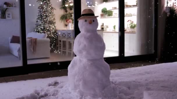 Flauschiger Schnee Fliegt Auf Der Abendterrasse Mit Schneemann Und Modernem — Stockvideo