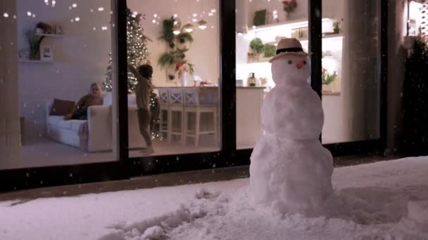 Niedlichen Kinder Spaß Hause Mit Schneeflocken Fallen Draußen Winter Abend — Stockvideo