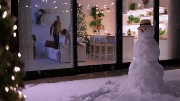 Χαριτωμένα Παιδιά Που Διασκεδάζουν Στο Σπίτι Νιφάδες Χιονιού Πέφτουν Εξωτερικούς — Αρχείο Βίντεο