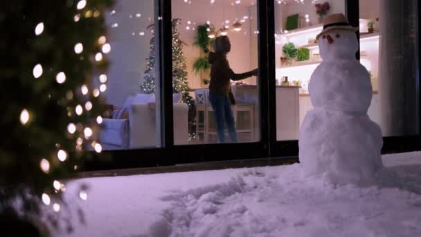 可爱的孩子们在家里玩的很开心 看着冬天的夜晚雪花飘落在户外的院子里 圣诞假期装饰舒适的公寓 — 图库视频影像