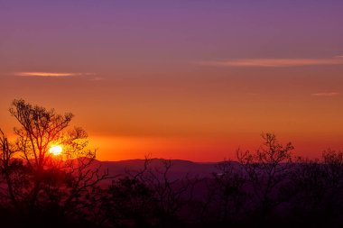 Sabah güneşi, ormanla kaplı dağ sırtlarının üzerinden doğuyor.