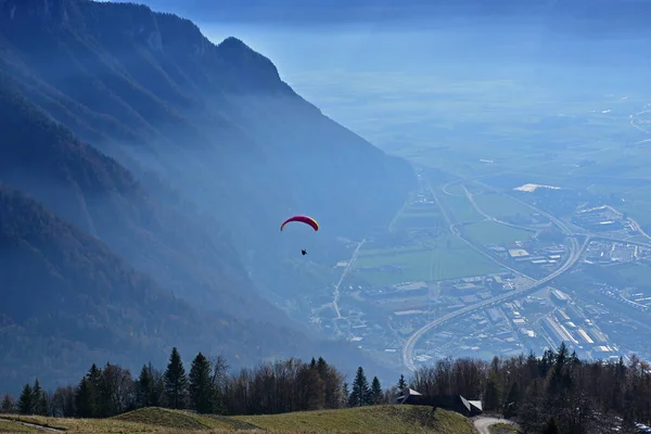 山の劇的な背景を持つ谷を離陸するパラグライダー — ストック写真
