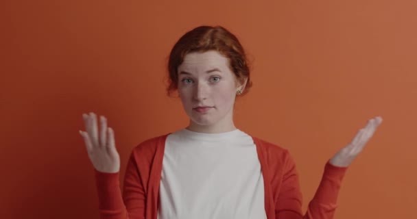 여자는 불확실 소녀가 당황을 표현하는 카메라를 그래서 신경쓰는가 스튜디오에서 주황색 — 비디오