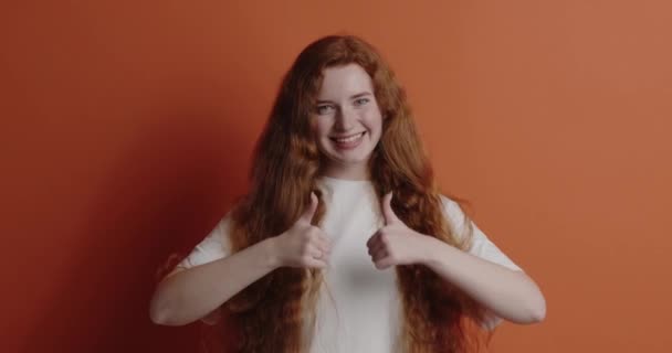 Vörös Mindkét Nagy Ujját Elszigetelte Mosolygós Lány Néz Kamera Fogas — Stock videók