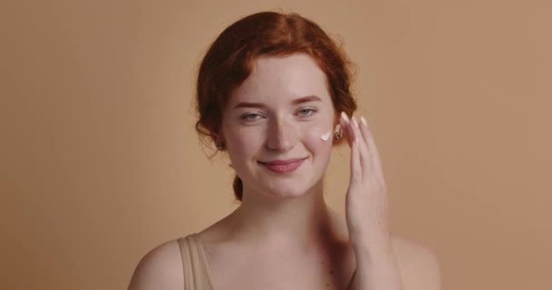 Mulher Gengibre Aplicando Creme Facial Close Modelo Feminino Satisfeito Aplicando — Vídeo de Stock