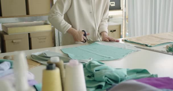 这个女人用亚麻布裁剪图案纸的全景 女裁缝在小工作室准备缝纫 时尚工作室 手工制衣的概念 时尚意识消费 — 图库视频影像