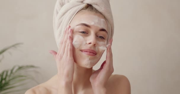 顔の皮膚ケア 泡石鹸で顔の皮膚を洗浄女性 顔のクレンジングアップを適用し 幸せな女の子のクレンジング顔 高解像度 — ストック動画