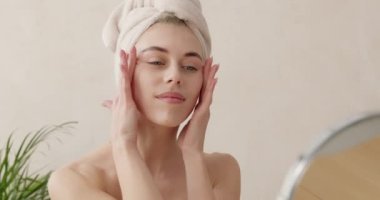Hayalperest kadın güzellik rutininden zevk alıyor. Kafasında havluyla yanaklarına dokunan genç kız evde yumuşak, mükemmel tenine sahip. Cilt bakımı kavramı 