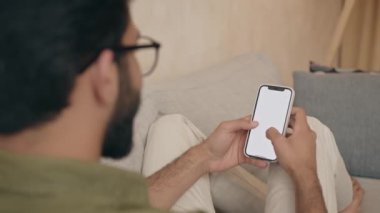Akıllı telefon kullanan bir adam, beyaz boş ekran. Uzay modelini kopyala. Kapalı alanda cep telefonuyla mesajlaşan genç bir öğrenci. Bağlantı, teknoloji, uygulamalar, modelleme, iletişim, web sitesi kavramı 