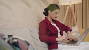 Ciddi bir kadın internetten e-posta haberlerini kontrol ediyor kanepeye oturuyor, internette arkadaş arıyor ya da bilgisayarda çalışıyor, blog yazıyor ya da evde ders çalışıyor. 