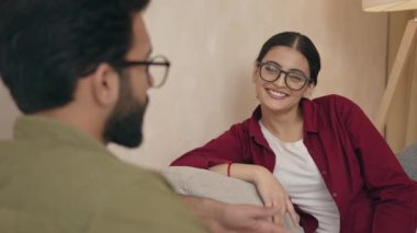 Mutlu evli çift rahat bir kanepede dinleniyor, rahat evlerinde sohbetin tadını çıkarıyor, konuşuyor, gülüyor, eğleniyor. İlişki, aşk, aile kavramı için gayrimenkul 
