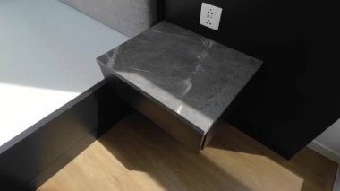 Karanlık evin içindeki yatağın başındaki modern çekmecede.